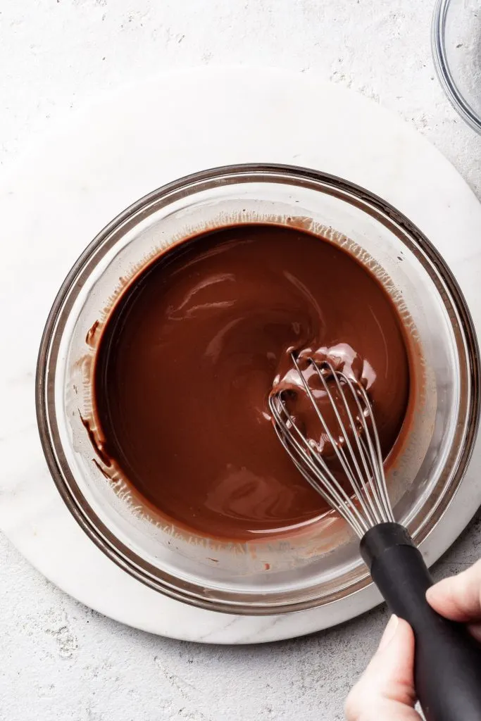 Clear glass bowl filled with melted chocolate. 